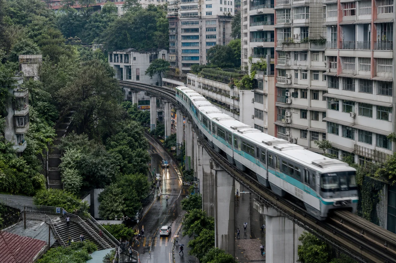 Illustrative editorial view of a monorail moving through a layered hillside city